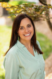 Amanda Rodgers Cumbo smiles while wearing a green shirt.